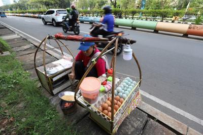 Pedagang sedang membuat kerak telor makanan khas Betawi yang masih bertahan dimasa pandemi di kawasan Kemayoran, Jakarta Pusat, Selasa (22/6/2021).