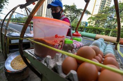 Pedagang sedang membuat kerak telor makanan khas Betawi yang masih bertahan dimasa pandemi di kawasan Kemayoran, Jakarta Pusat, Selasa (22/6/2021).