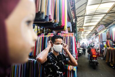Anggota Polsek Cimanggis saat membagikan masker untuk pedagang dan pengunjung di Pasar PAL Cimanggis, Depok, Jawa Barat, Selasa (22/6/2021).