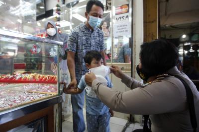 Anggota Polsek Cimanggis saat membagikan masker untuk pedagang dan pengunjung di Pasar PAL Cimanggis, Depok, Jawa Barat, Selasa (22/6/2021).