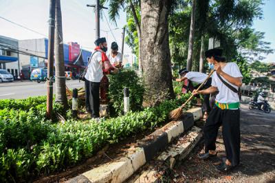 Petugas Suku Dinas Kehutanan Ciracas saat membersihkan taman di Jalan Raya Bogor, Jakarta Timur, Selasa (22/6/2021).