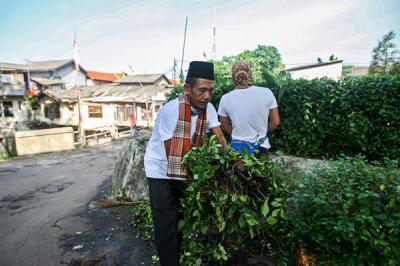 Petugas Suku Dinas Kehutanan Ciracas saat membersihkan taman di Jalan Raya Bogor, Jakarta Timur, Selasa (22/6/2021).