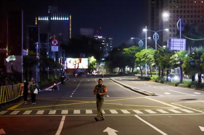 Petugas gabungan menutup akses menuju Jalan Asia Afrika, Jakarta Pusat, Senin (21/6/2021).