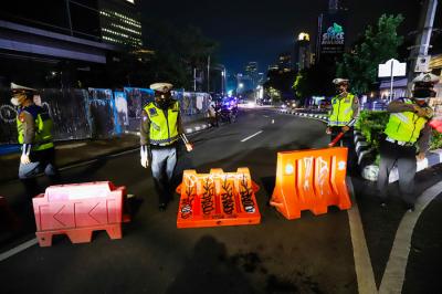 Petugas gabungan menutup akses menuju Jalan Asia Afrika, Jakarta Pusat, Senin (21/6/2021).