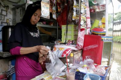 Sukarni (47) melayani pembeli di warung derek di kawasan Kampung Kebalen, Mampang, Jakarta Selatan, Selasa (22/6/2021).