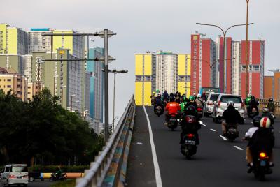Anak-anak bermain skateboard dengan berlatar belakang gedung Rumah Sakit Darurat Covid-19 (RSDC) Wisma Atlet, Kemayoran, Jakarta Pusat, Selasa (22/6/2021).