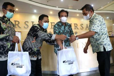 Kepala BP Jamsostek Surabaya Rungkut Rudi Susanto (kanan) menyerahkan bantuan APD Covid-19 lengkap di RSI Jemursari Surabaya, Jawa Timur, Rabu (23/6/2021).