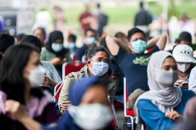 Puluhan warga antre menunggu giliran registrasi vaksinasi di Jakarta International Equestrian Park, Jakarta Timur, Rabu (23/6/2021).