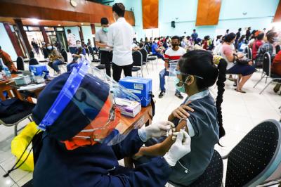 Warga saat mengikuti vaksinasi Covid-19 dengan target vaksinasi 1 juta dosis per hari di GOR Jakarta Barat, Jumat (25/6/2021).