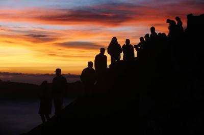 Warga Tengger menanti matahari terbit di bibir kawah Gunung Bromo pada perayaan Yadnya Kasada tahun ke 1943 Saka di Probolinggo, Jawa Timur, Sabtu (26/6/2021).