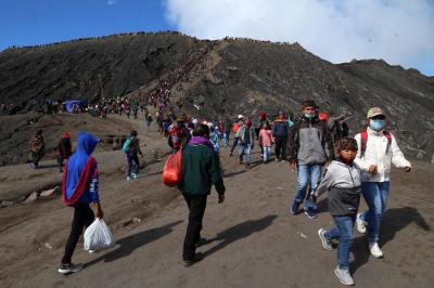 Warga Tengger menanti matahari terbit di bibir kawah Gunung Bromo pada perayaan Yadnya Kasada tahun ke 1943 Saka di Probolinggo, Jawa Timur, Sabtu (26/6/2021).