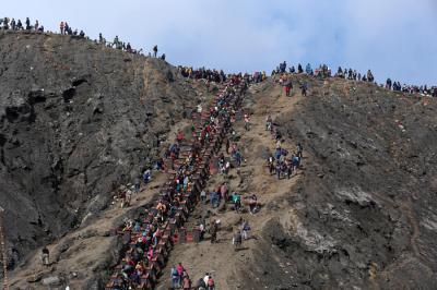 Warga Tengger menanti matahari terbit di bibir kawah Gunung Bromo pada perayaan Yadnya Kasada tahun ke 1943 Saka di Probolinggo, Jawa Timur, Sabtu (26/6/2021).
