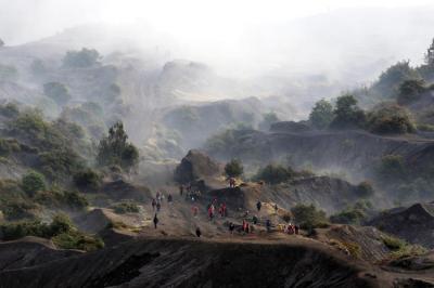 Warga Tengger menanti matahari terbit di bibir kawah Gunung Bromo pada perayaan Yadnya Kasada tahun ke 1943 Saka di Probolinggo, Jawa Timur, Sabtu (26/6/2021).