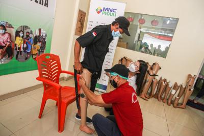 Miss Indonesia 2020 Pricilia Carla Yules membantu petugas memasang kaki palsu di Yayasan Etika Moral Indonesia, Jakarta, Minggu (27/6/2021).