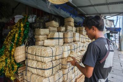 Penjual merapikan barang dagangan besek dari anyaman bambu di Pasar Jatinegara, Jakarta, Senin (28/6/2021).
