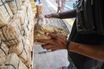 Penjual merapikan barang dagangan besek dari anyaman bambu di Pasar Jatinegara, Jakarta, Senin (28/6/2021).