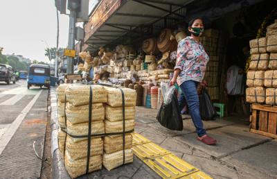 Penjual merapikan barang dagangan besek dari anyaman bambu di Pasar Jatinegara, Jakarta, Senin (28/6/2021).