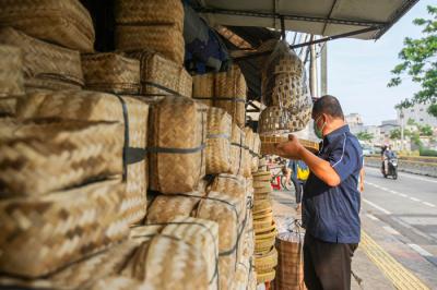 Penjual merapikan barang dagangan besek dari anyaman bambu di Pasar Jatinegara, Jakarta, Senin (28/6/2021).