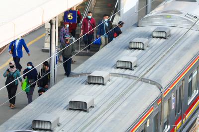 Calon penumpang berjalan menuju rangkaian kereta rel listrik (KRL) di Stasiun Tanah Abang, Jakarta Pusat, Senin (28/6/2021).