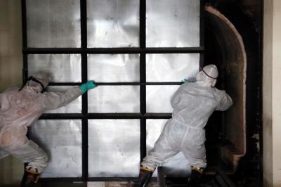 Petugas Krematorium mengenakan Hazmat dan APD memasukkan peti jenazah kedalam tungku pembakaran di Krematorium Keputih, Surabaya, Selasa (29/6/2021).
