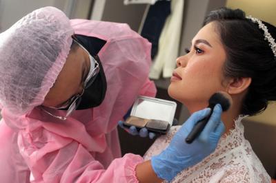 Perias Pengantin Itha Dantjie saat merias calon pengantin di kawasan Margonda, Depok, Jawa Barat, Sabtu (26/6/2021).