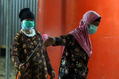 Para Modin saling membantu mengenakan alat pelindung diri (APD) lengkap di tempat pemulasaraan darurat Keputih Surabaya, Rabu (30/6/2021).