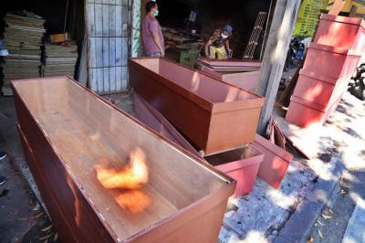 Perajin kayu menyelesaikan produksi peti mati khusus jenazah Covid-19 dikawasan Menur Surabaya, Jawa Timur, Rabu (30/6/2021).