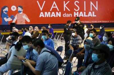 Warga mendapatkan suntikan vaksin Covid-19 saat mengikuti vaksinasi massal di Auditorium Poltekkes Kemenkes Surabaya, Jawa Timur, Rabu (30/6/2021).