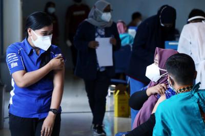 Warga mendapatkan suntikan vaksin Covid-19 saat mengikuti vaksinasi massal di Auditorium Poltekkes Kemenkes Surabaya, Jawa Timur, Rabu (30/6/2021).