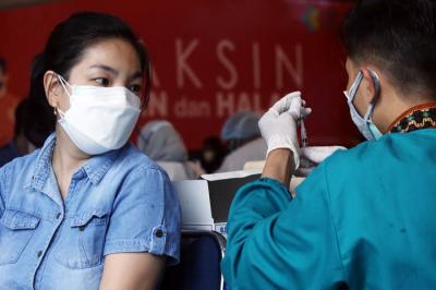Warga mendapatkan suntikan vaksin Covid-19 saat mengikuti vaksinasi massal di Auditorium Poltekkes Kemenkes Surabaya, Jawa Timur, Rabu (30/6/2021).