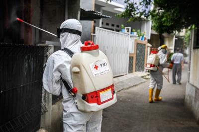 Petugas Palang Merah Indonesia Jaktim saat melakukan penyemprotan cairan disinfektan ke rumah warga di Kelurahan Tengah, Jakarta Timur, Kamis (1/7/2021).