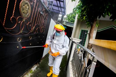 Petugas Palang Merah Indonesia Jaktim saat melakukan penyemprotan cairan disinfektan ke rumah warga di Kelurahan Tengah, Jakarta Timur, Kamis (1/7/2021).