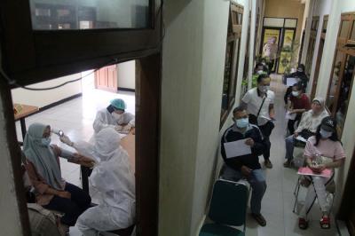 Petugas menyuntikkan vaksin Covid-19 Sinovac kepada warga di Mapolsek Pamulang, Tangerang Selatan, Banten, Kamis (1/7/2021).