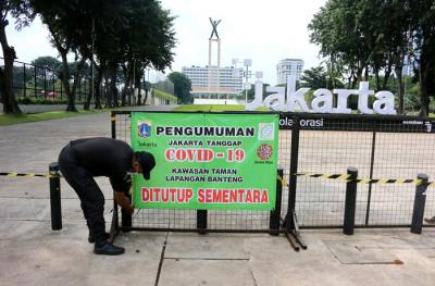 Petugas Satpol PP berjaga dikawasan taman kota lapangan banteng yang ditutup sementara oleh Pemprov DKI Jakarta, Kamis (1/7/2021).