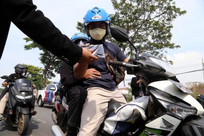 Pembagian masker dan hand sanitizer pada nelayan dan masyarakat di jalur pintu Jembatan Suramadu, Kenjeran Surabaya, Jawa Timur, Jumat (2/7/2021).