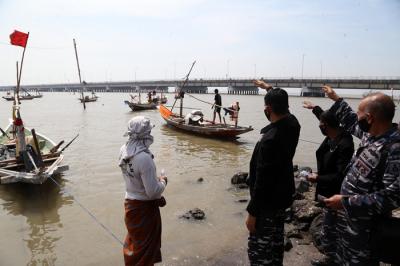 Pembagian masker dan hand sanitizer pada nelayan dan masyarakat di jalur pintu Jembatan Suramadu, Kenjeran Surabaya, Jawa Timur, Jumat (2/7/2021).