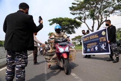 Pembagian masker dan hand sanitizer pada nelayan dan masyarakat di jalur pintu Jembatan Suramadu, Kenjeran Surabaya, Jawa Timur, Jumat (2/7/2021).