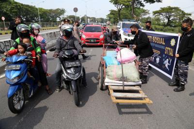Pembagian masker dan hand sanitizer pada nelayan dan masyarakat di jalur pintu Jembatan Suramadu, Kenjeran Surabaya, Jawa Timur, Jumat (2/7/2021).