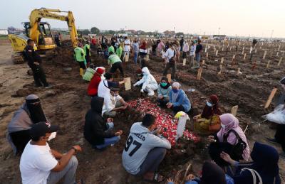 Keluarga berdoa dilokasi pemakaman Khusus Jenazah Covid-19 di TPU Rorotan, Cilincing, Jakarta Utara, Jumat (2/7/2021).