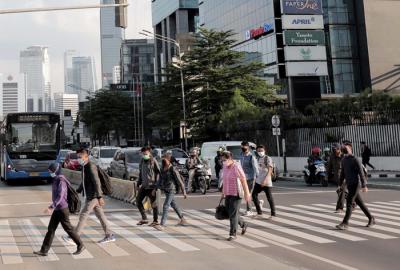 Sejumlah pekerja berjalan di jalur pedestrian Jalan Jenderal Sudirman, Jakarta, Jumat (2/7/2021).