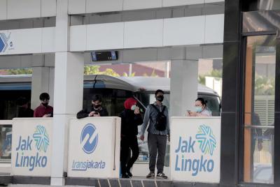 Sejumlah pekerja berjalan di jalur pedestrian Jalan Jenderal Sudirman, Jakarta, Jumat (2/7/2021).