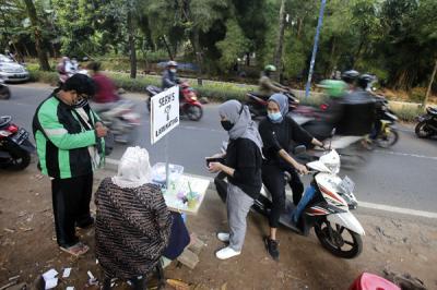 Ade Kalsum (46) tengah memperbaiki KTP elektronik milik warga di Jalan M Kahfi II, Jagakarsa, Jakarta Selatan, Jumat (2/7/2021).