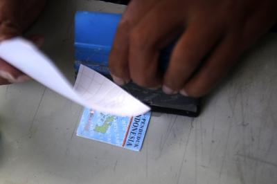 Ade Kalsum (46) tengah memperbaiki KTP elektronik milik warga di Jalan M Kahfi II, Jagakarsa, Jakarta Selatan, Jumat (2/7/2021).