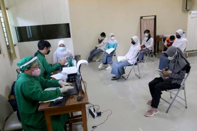 Siswa menunjukan kartu vaksinasi Covid-19 di SMK Negeri 15 Jakarta, Jumat (2/7/2021).