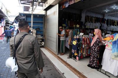 Petugas gabungan menyisir Pedagang Kali Lima (PKL) dan pertokoan dikawasan Wisata Religi Sunan Ampel Surabaya, Jawa Timur, Minggu (4/7/2021).