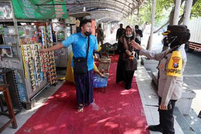 Petugas gabungan menyisir Pedagang Kali Lima (PKL) dan pertokoan dikawasan Wisata Religi Sunan Ampel Surabaya, Jawa Timur, Minggu (4/7/2021).