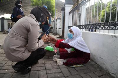 Para peziarah meninggalkan area makam usai berdoa ketika didatangi aparat gabungan di kawasan Makan Sunan Ampel Surabaya, Jawa Timur, Minggu (4/7/2021).