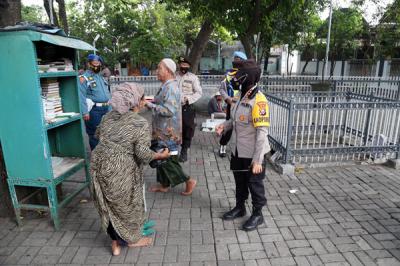 Para peziarah meninggalkan area makam usai berdoa ketika didatangi aparat gabungan di kawasan Makan Sunan Ampel Surabaya, Jawa Timur, Minggu (4/7/2021).