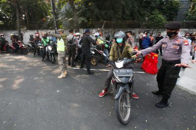 Petugas gabungan dari TNI, Polri, Satpol PP dan Dinas Perhubungan memutar balikan pengendara di Pos Penyekatan, Jalan Raya Daan Mogot, Senin (5/7/2021).