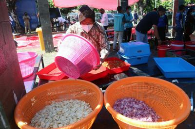 Mensos Tri Rismaharini ikut memasak untuk para pejuang Covid-19 di Dapur Umum di area halaman Convention Hall Surabaya, Jawa Timur, Senin (5/7/2021).